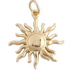 A polished gold sun pendant charm with radiating flame-like rays and a circular center, shown on a plain white background.