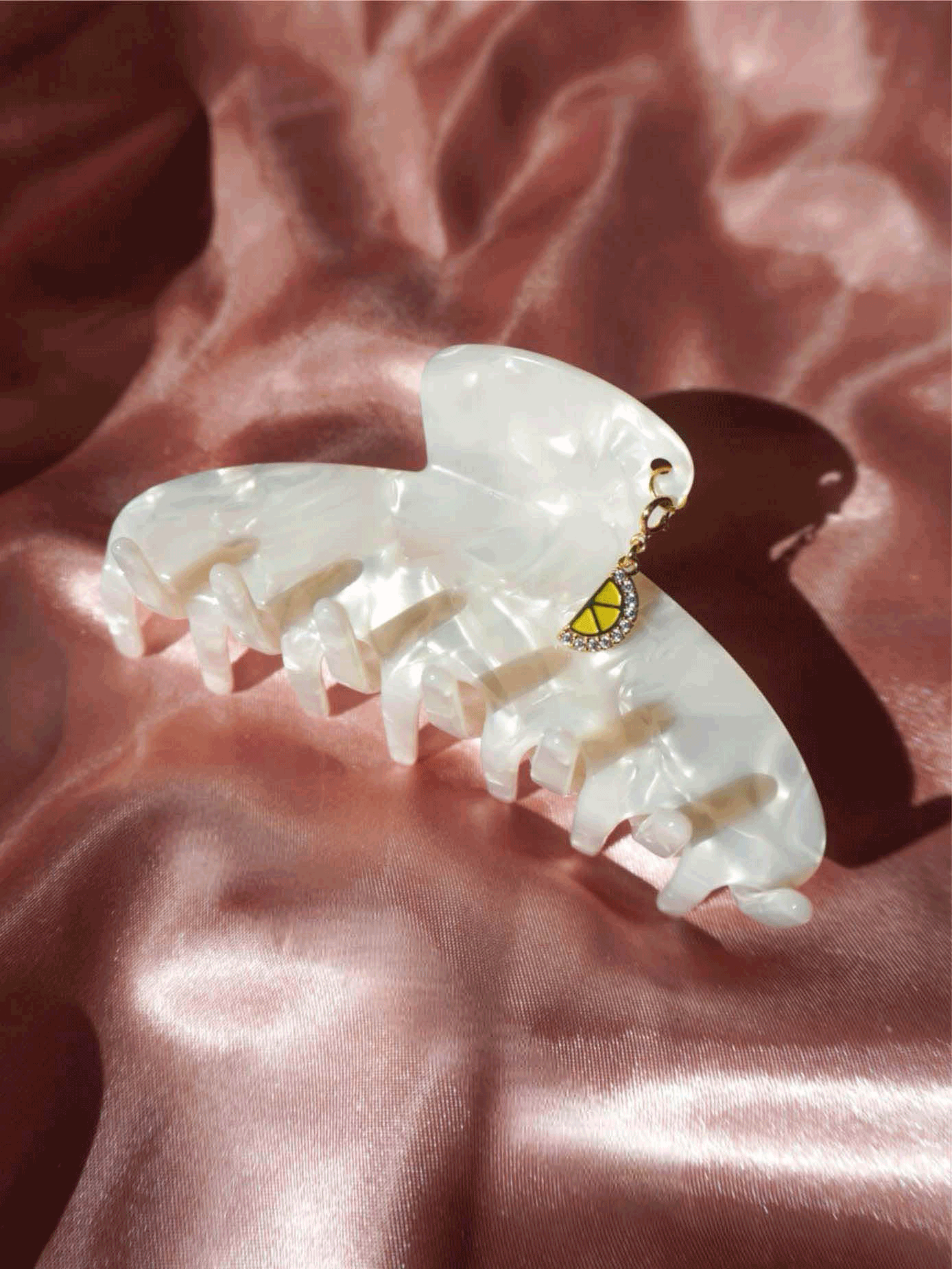 Ivory Claw Clip with charms on pink fabric