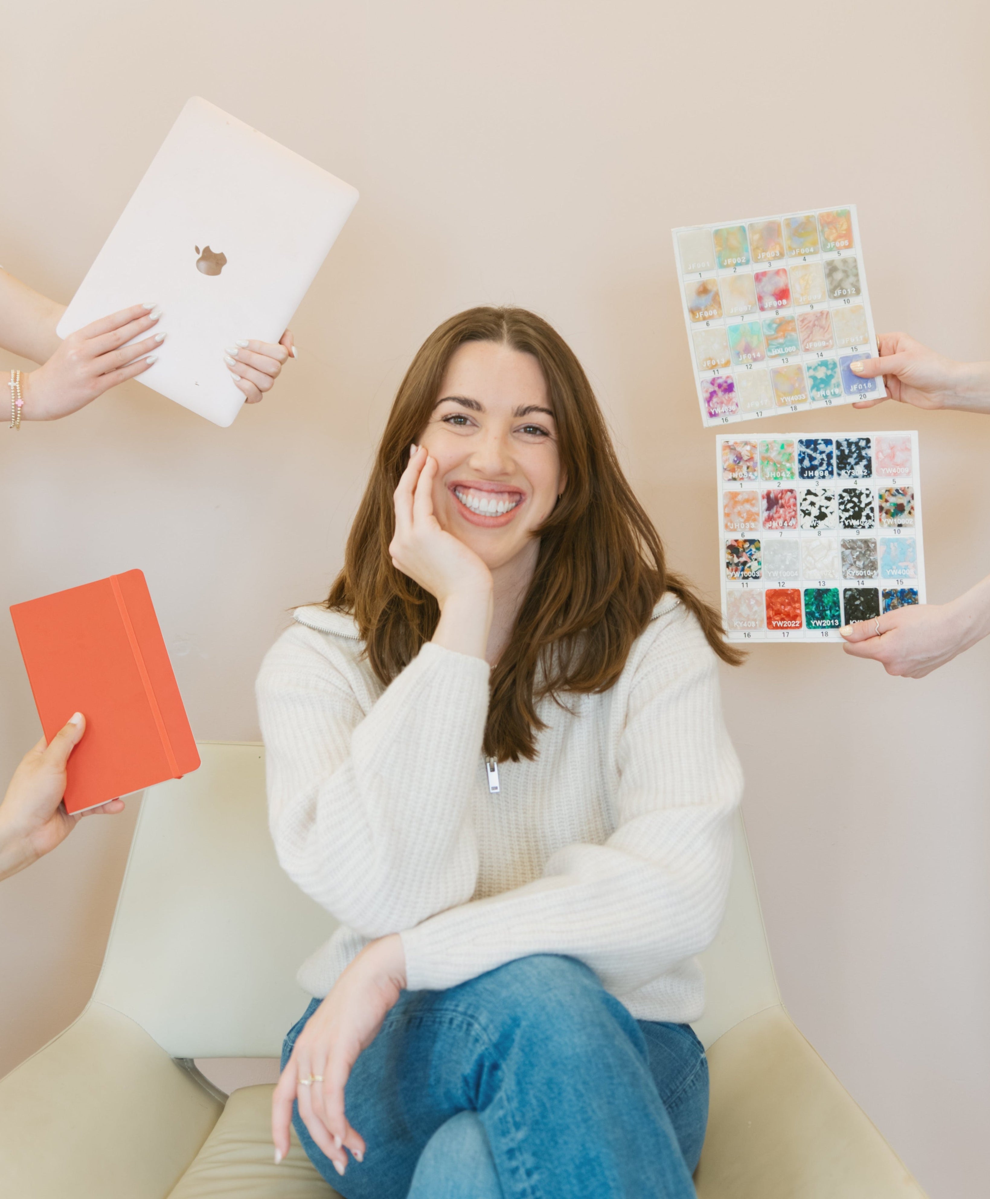 Woman sitting on a couch with people holding various items around her